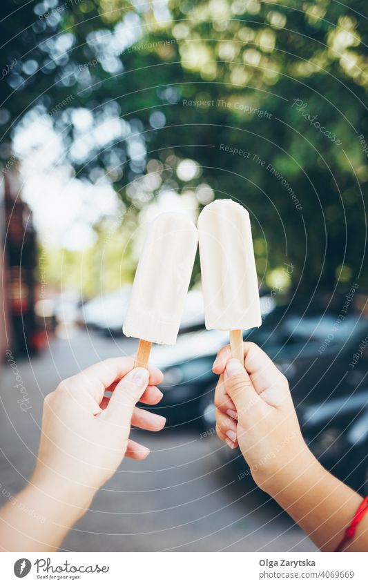 Two hands holding two popsicles. ice cream woman food summer fun white stick bar cool dessert eating fresh frozen happiness organic sky sweet vanilla green