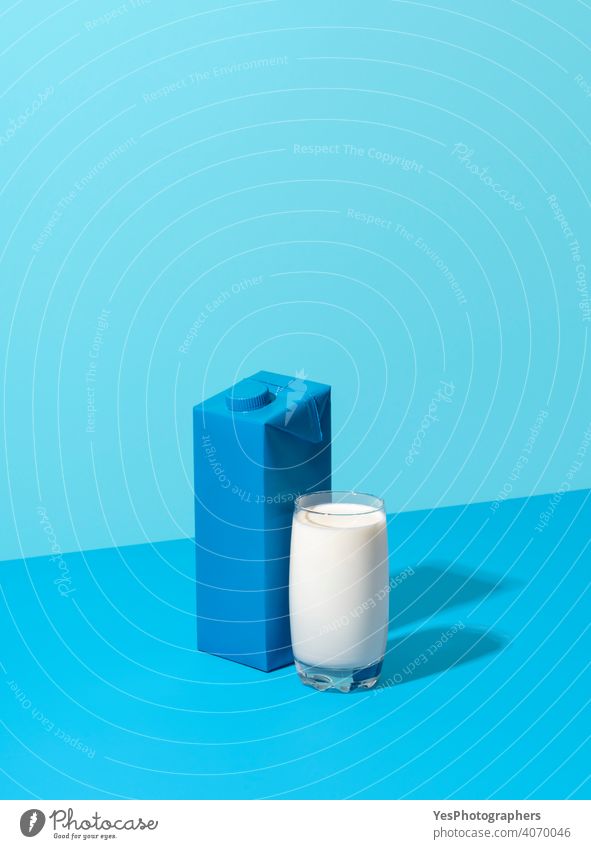 Glass of milk and carton milk box isolated on a blue background. abstract beverage blank breakfast bright calcium cardboard carton box cartoon colored colorful