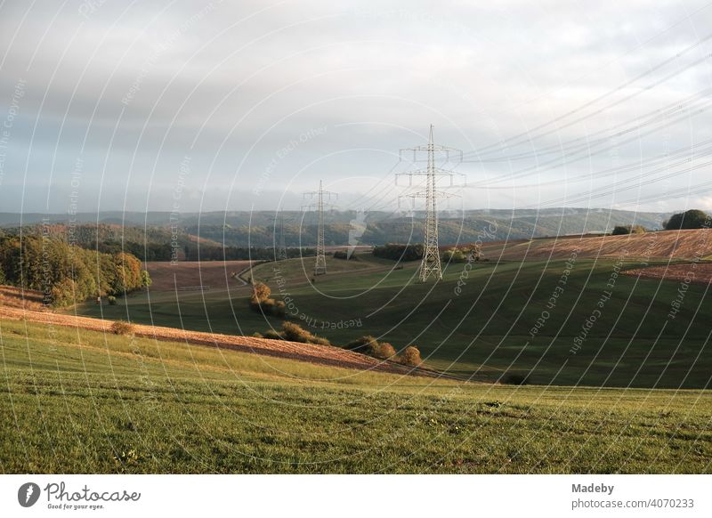 Electricity pylons on hills with meadows and fields in autumn in Gembeck at the Twistetal in the district of Waldeck-Frankenberg in Hesse power line