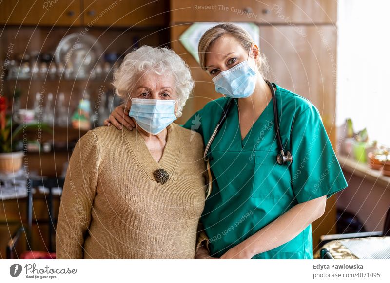 Senior woman visited by home care specialist during lockdown coronavirus face mask real people covid senior nurse elderly candid genuine mature female Caucasian