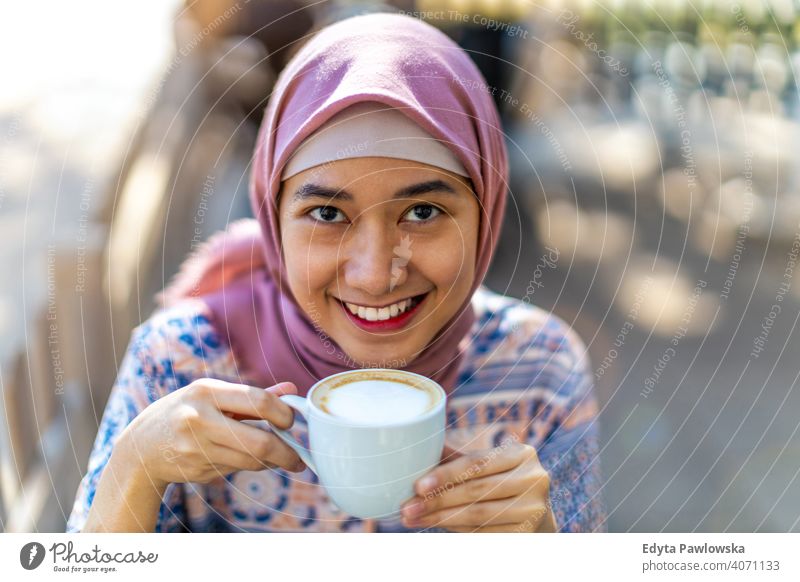 Happy Young Muslim Woman Drinking Coffee hijab headscarf muslim islam arabic woman summer girl people young adult female lifestyle active outdoors millennial