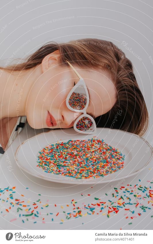 Fun photo of woman looking at plate with colorful sweet confetti. anniversary anxiety background beautiful birthday candy celebration copyspace creative