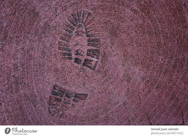 footprint on the red ground, textured background Footprint Red Pavement shoe print track old abstract street