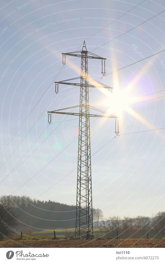 Electricity pylons in the landscape with a sun star in the sky Energy industry energy supply transport route high voltage Cables Overhead line