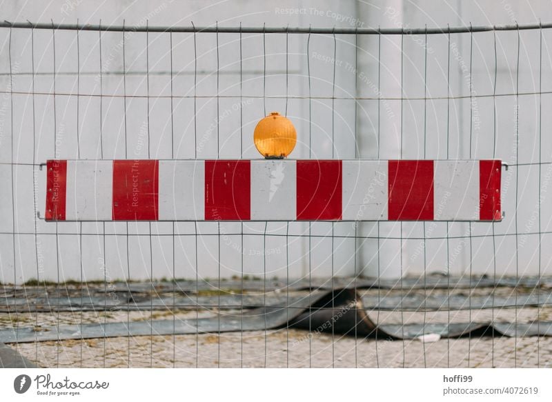 Barque with lamp in front of construction fence Reddish white Metalware Abstract Construction site Barrier Line Control barrier Protection Fenced in Fences