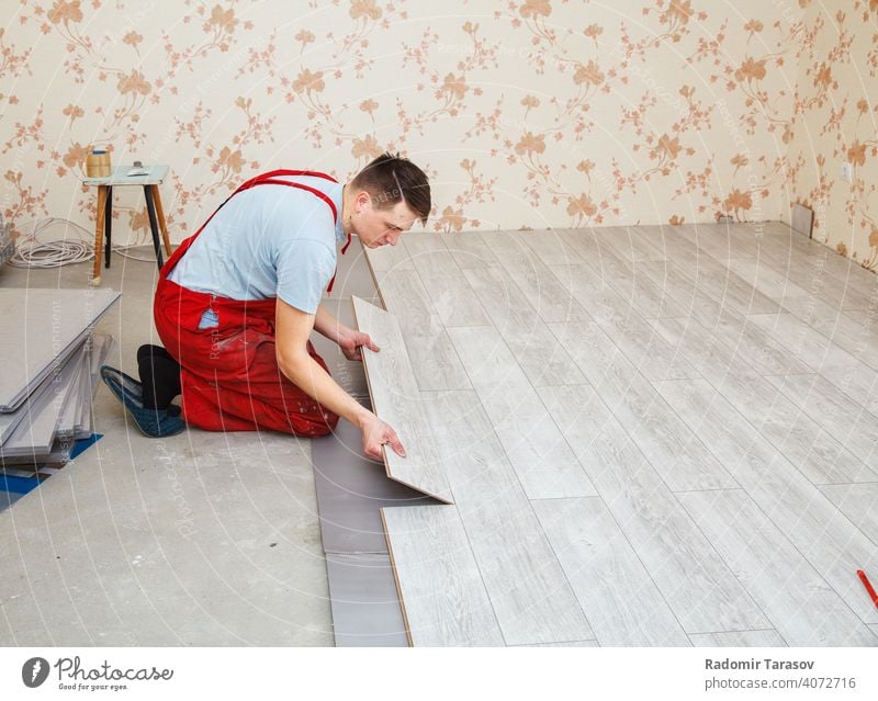 handyman laying down laminate flooring boards installing construction professional repairman working indoor wooden worker plank interior home put constructing