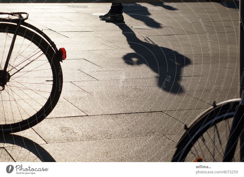 Waiting between wheels Human being Shadow Stand Bicycle Places Pedestrian precinct urban Shadow play on one's own Individual Wheels