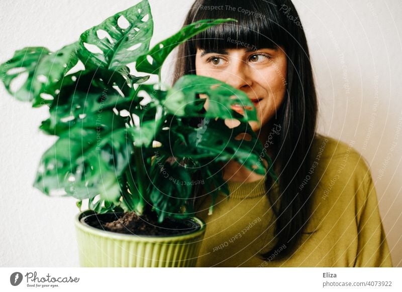 Woman with green houseplant. Monkey Monstera adansonii. Plant Houseplant deliciosa monster Pot plant Green Foliage plant monstera adansonii Flat (apartment)