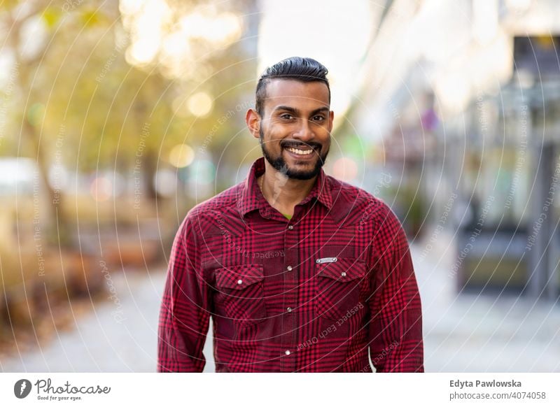 Portrait of a beautiful smiling man Indian ethnicity looking at the camera Sinhalese asian bearded outside street urban standing outdoors Warsaw one casual