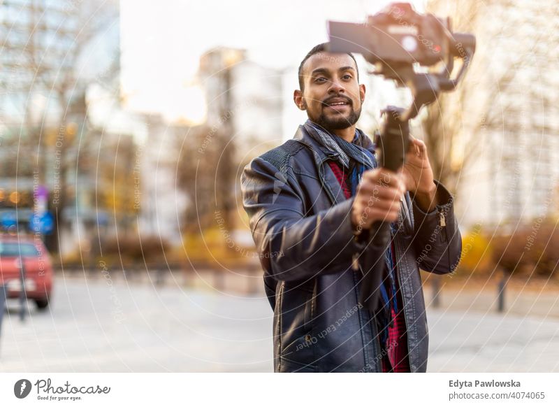 Man filming a vlog with camera in the city video blogger vlogger journalist influencer photographer technology travel tourist explorer freelancer reportage