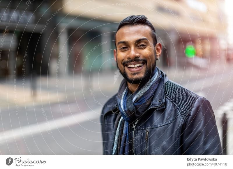 Portrait of a beautiful smiling man Indian ethnicity looking at the camera Sinhalese asian bearded outside street urban standing outdoors Warsaw one casual