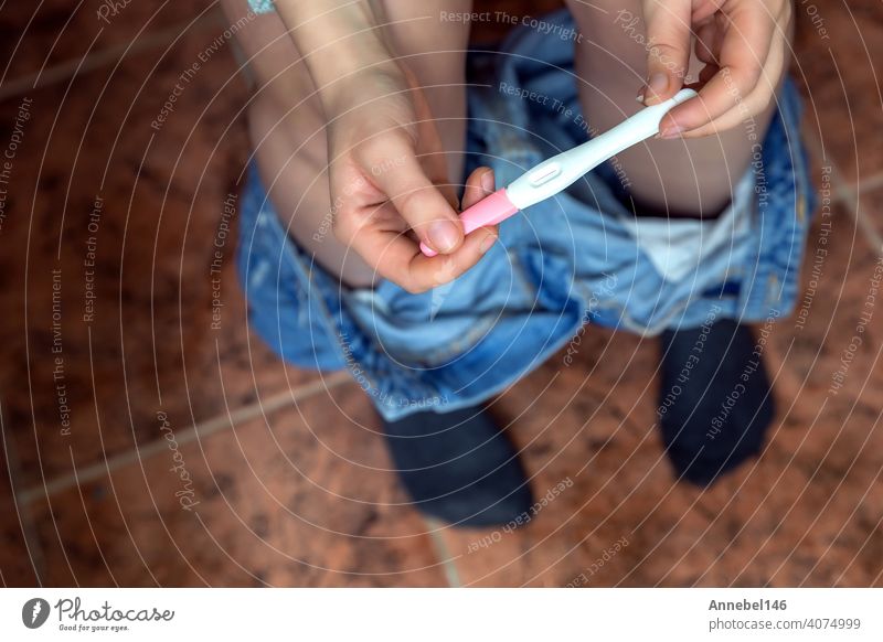 Young woman checking results of a pregnancy test in bathroom close-up, new life,family,mother,baby concept female young holding pregnant positive motherhood