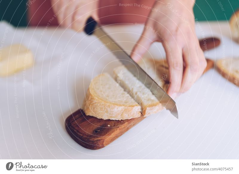 Woman cutting bread at  kitchen hands breakfast making green background dress marble cooking home toasted spoon table calories eating young protein jar