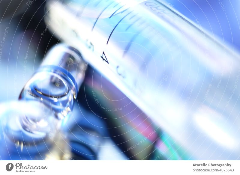 A syringe and an ampule in blur addiction ampoule antidote blue bokeh closeup concept coronavirus dark death dependency dramatic drop droplets drug drugs