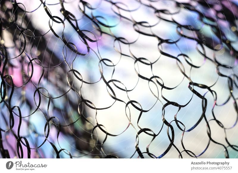 Close up image of a metal net with colorful background abstract art blur blurry cell connection creativity design fine fine art focus form grid iron knot lens