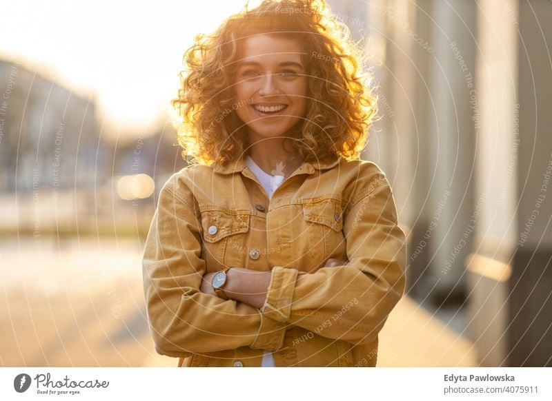Portrait of young woman with curly hair in the city natural sunlight urban hipster stylish positive sunny cool afro joy healthy freedom sunset enjoyment summer
