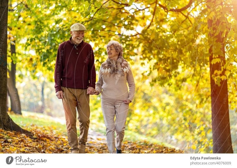 Happy senior couple enjoying a day outdoors in autumn love real people retired pensioner retirement aged grandmother grandparent grandfather two togetherness