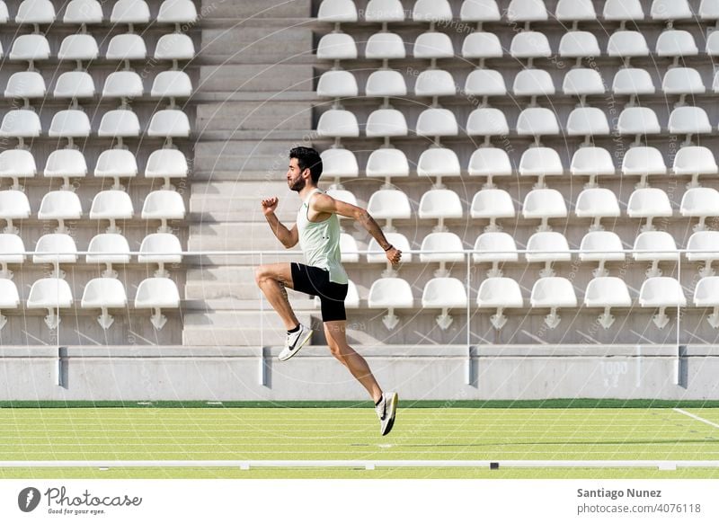 Athlete Practicing in Athletic Track side view jumping running caucasian one person sports track strength athlete runner action stadium track and field exercise