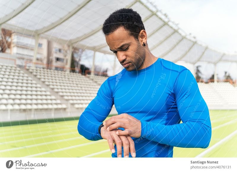 Black Athlete Using Watch portrait looking black man african american using track and field one person watch athletic athlete runner hands looking down activity