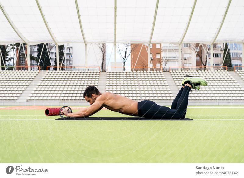 Black Athlete Stretching in Sports Track side view lying sports track athlete african american stretching one person foam roller black man runner focus trainers