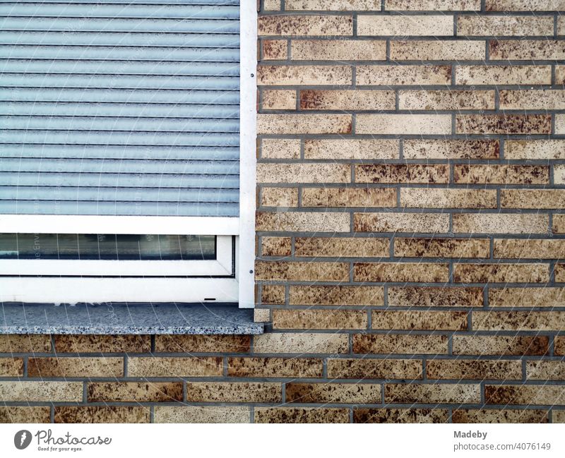 Brown mottled clinker brick façade with window and downcast grey window shutter in Bielefeld in the Teutoburg Forest in East Westphalia-Lippe Facade