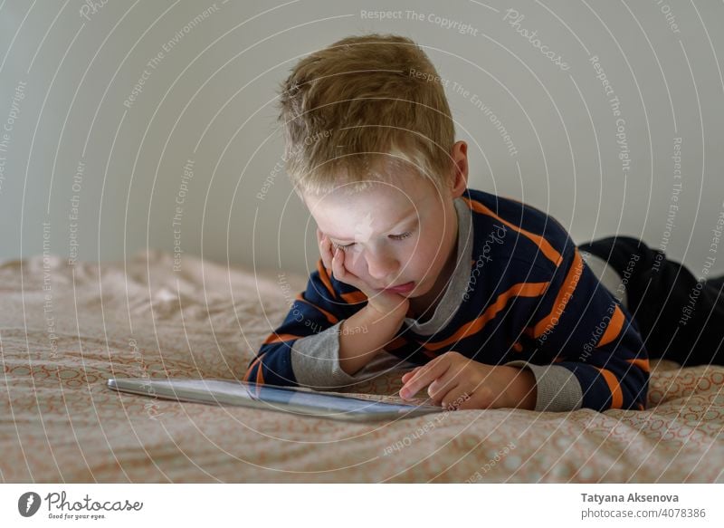 Boy using tablet on bed child boy internet technology learning modern home digital leisure education digital tablet communication childhood person indoor
