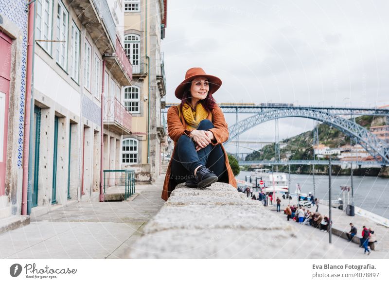 young beautiful woman sitting by the river at sunset enjoying Porto views. Travel concept travel city sightseeing urban caucasian people tour tourism spring