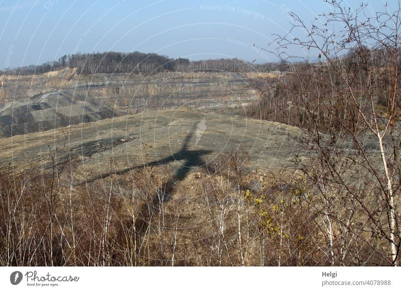 huge wind turbine casts shadow into quarry Quarry Pinwheel Wind energy plant Shadow shadow cast birches Landscape Nature Environment Spring Sunlight Light