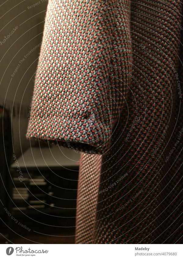 Sleeves of a coat made of coarse fabric with interwoven coloured threads in the evening in a shop window in the north end of Frankfurt am Main in Hesse, Germany