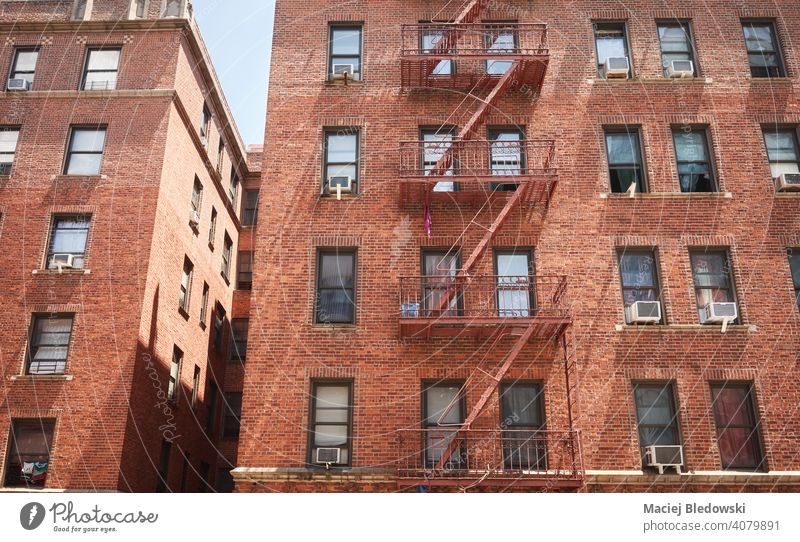 Old red brick building with fire escape, New York City, USA. city tenement house NYC Manhattan townhouse old residential home apartment facade ladder urban