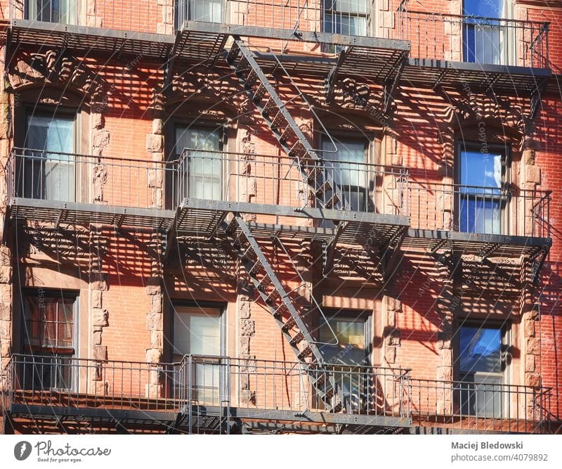 Old building with iron fire escape, New York City, USA. city tenement house NYC Manhattan townhouse old residential home brick apartment facade ladder urban