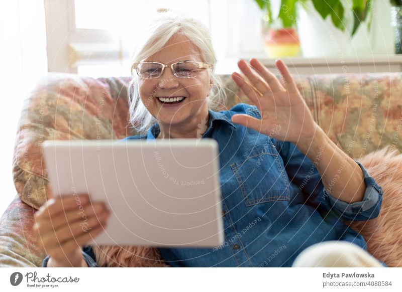 Senior woman using digital tablet at home smiling happy enjoying positivity vitality confidence people senior mature casual female Caucasian elderly house old