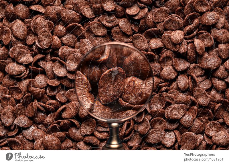 Chocolate cereal flakes through a magnifier. Background of cocoa cornflakes cereals above view abundance backdrop background breakfast brown childhood chocolate