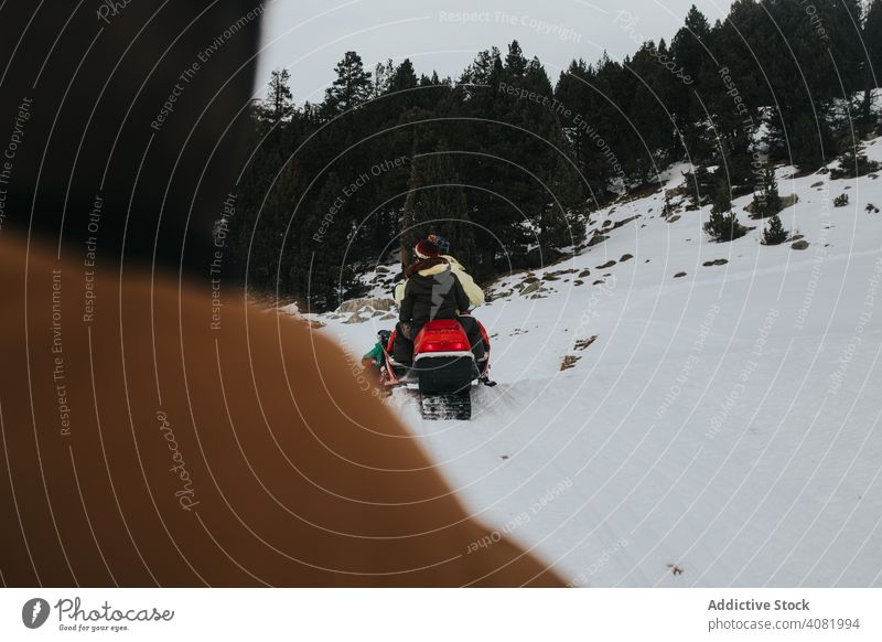 Anonymous people riding snowmobile winter slope cold adventure fun activity extreme recreation vehicle lifestyle leisure transport modern contemporary frost