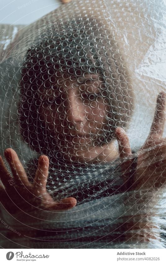 Woman entangled in bubble wrap woman female plastic reduce resources destruction trash pollute garbage sustainability disposal concept environmental