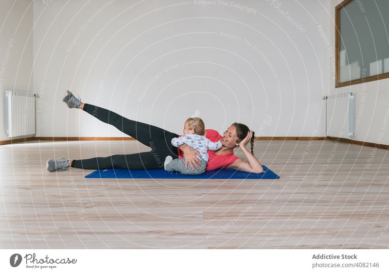 Mother exercising with baby in gym mother exercise workout lying floor abs fitness modern lifestyle woman kids children infants happy smiling cheerful joy