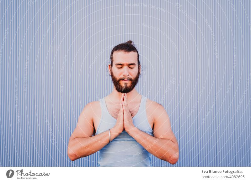 man in the city practicing yoga sport. blue background. healthy lifestyle urban muscular concentration position people young body meditating meditation beauty