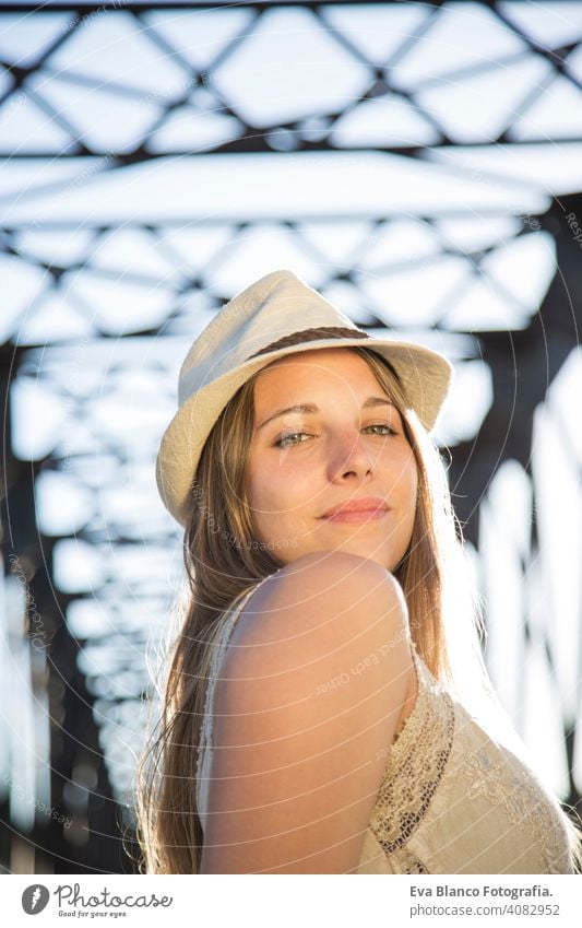 portrait of a young woman at sunset Portrait outdoors happy blonde hat blue eyes bridge summer sunny hair happiness lifestyle face beautiful fun white person