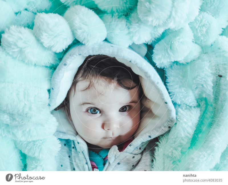 Little baby wrapped up with a warm green blanket portrait baby girl artistic winter cozy rug warm clothes home blue eyes lovely adorable babyhood childhood