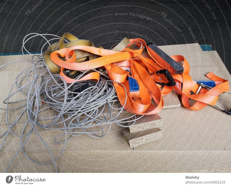 Utensils of a moving company with tension belt in orange and grey rope on wooden boards in the city centre of Frankfurt am Main in Hesse relocation Moving Help