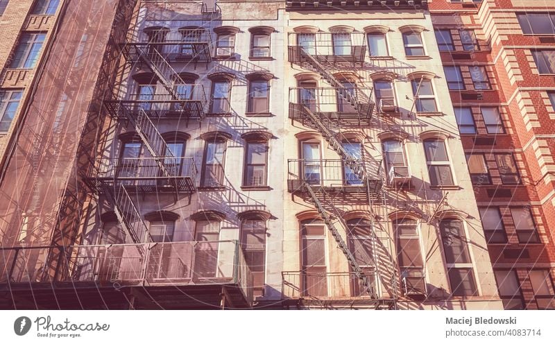 Old townhouse buildings with iron fire escapes, color toning applied, New York City, USA. city old tenement retro NYC Manhattan residential home apartment