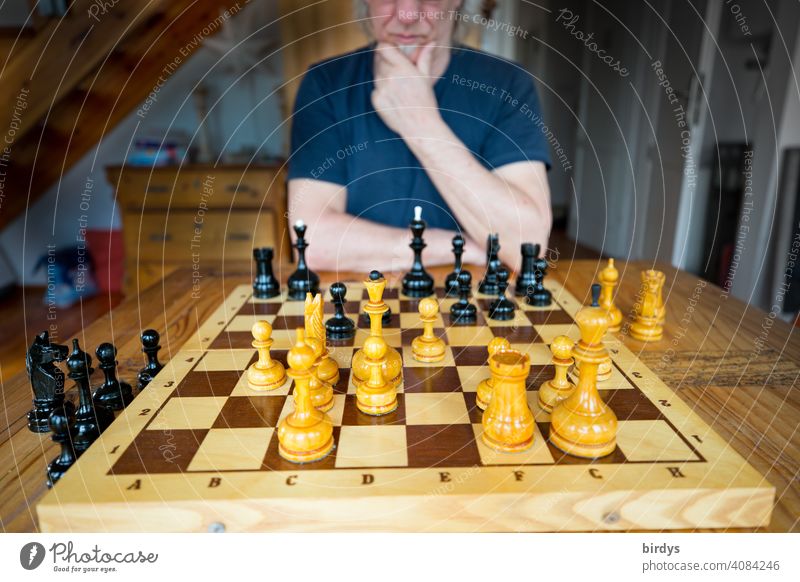 Chess player in pensive pose in front of a chessboard Chess Player Chessboard Chessmen ponder think Concentrate Chess piece Board game Adversary Game of chess