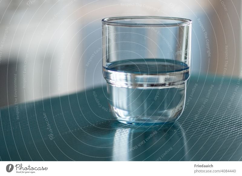 Water glass half full or half empty Glass Beverage Fluid Blue at home Drinking Minimalistic Visual spectacle blurred background Frontal Close-up