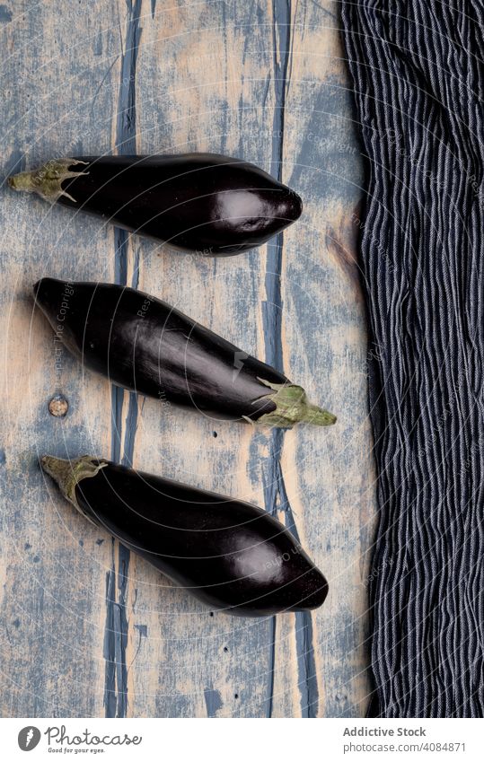 Ripe eggplants on shabby tabletop fabric ripe fresh rustic food healthy vegetable vegan ingredient raw diet cloth napkin weathered grungy agriculture grocery