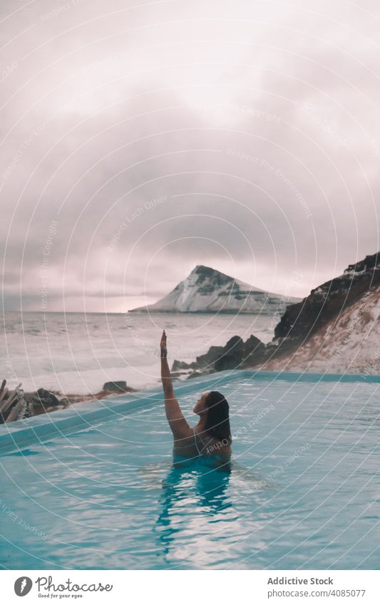 Woman in pool near sea and hills on shore woman cliff young hand side water resting coast rock sky stormy cloudy summer female relaxation healthy nature power
