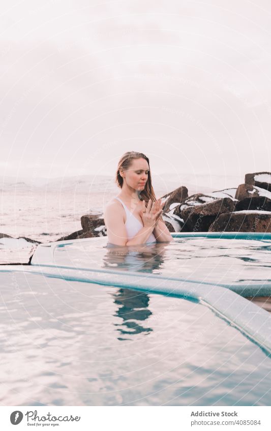 Woman sitting in pool near stones woman young resting water closed eyes rock sky cloudy summer female body relaxation healthy nature leisure lifestyle heaven