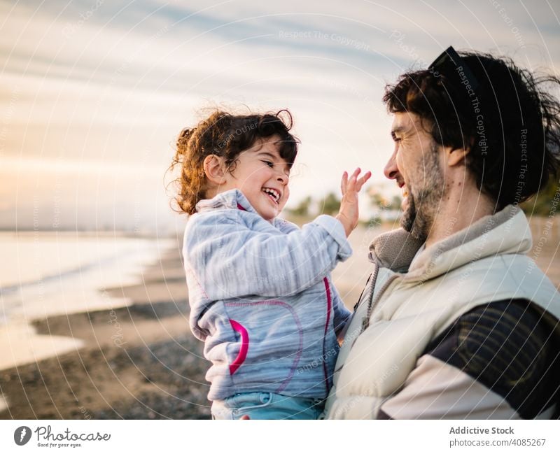 father holding little daughter at the beach hug ocean dad lifestyle happiness child love day girl fun caucasian male cute kid female playing sea outside happy