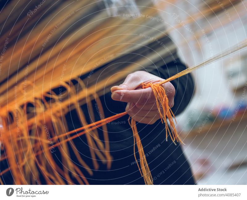 Crop person holding threads on loom weaver factory cotton industrial craft textile weaving yarn clothing fabric traditional fiber machine industry manufacture