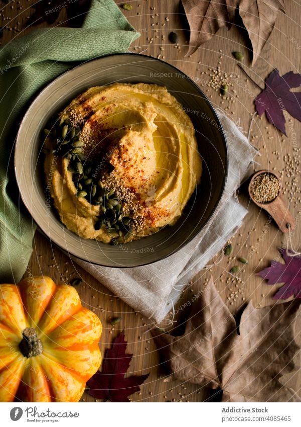 Dried leaves and napkins near pumpkin hummus seeds sesame autumn table dried cloth food vegan healthy homemade cuisine rustic lunch dinner diet traditional