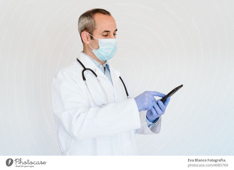 doctor wearing protective mask and gloves indoors using mobile phone. Corona virus concept technology internet wireless man professional corona virus hospital